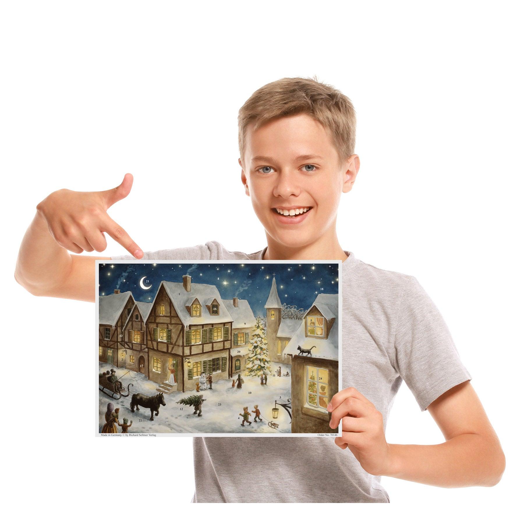 Kind mit Adventskalender "Weihnachtsabend im Dorf" in der Hand.
