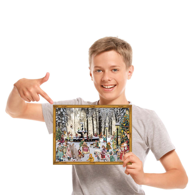 Junge mit Adventskalender "verschneiter Brunnen" in der Hand